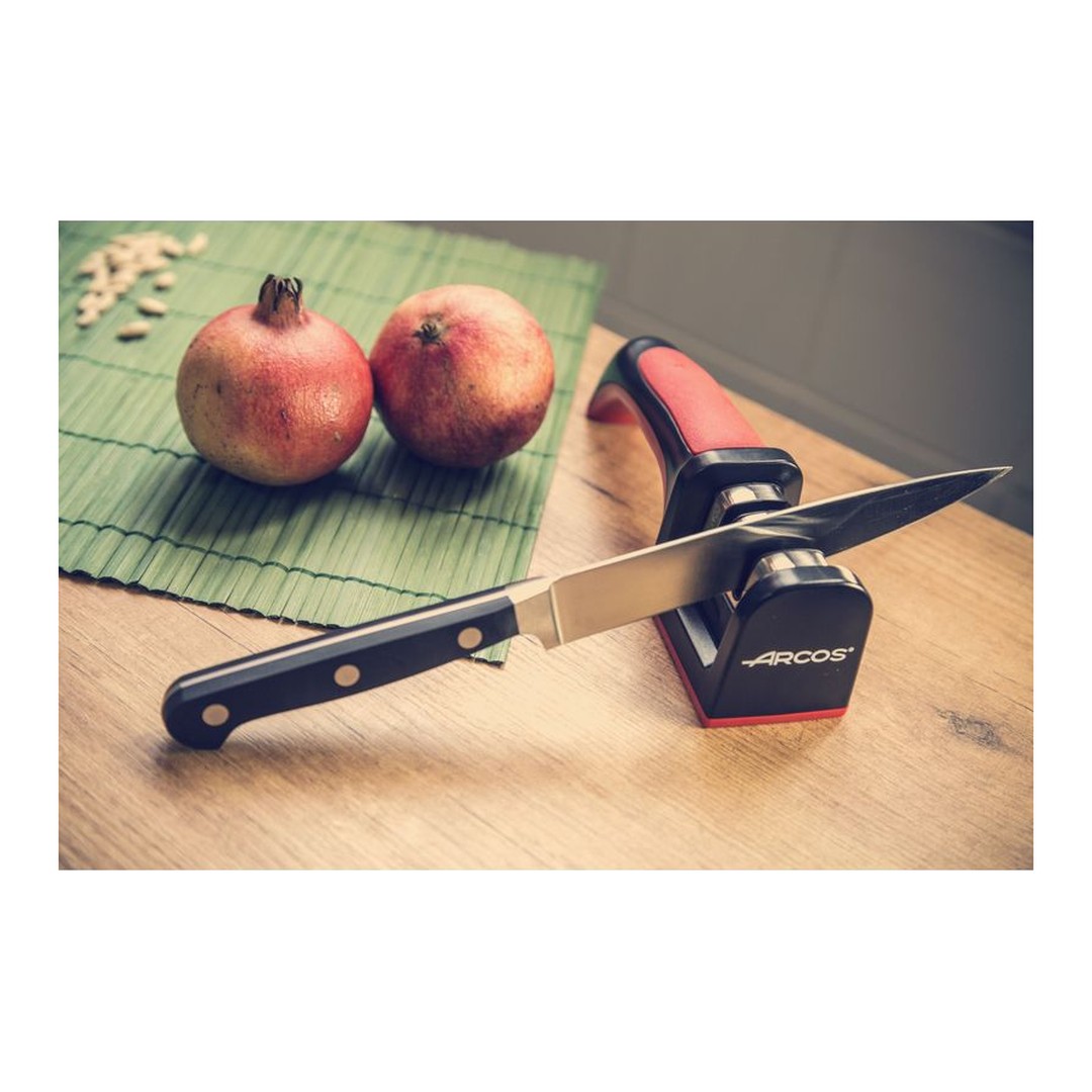 Afilador de cuchillos Arcos 610600 con mango rojo y negro en uso